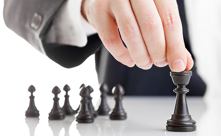 Imagem conceitual de liderança. Mão de executivo com terno jogando xadrez.